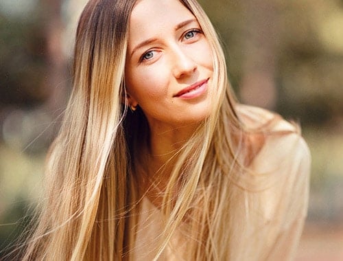 Girl with medium balayage hair flowing in slight breeze in an outdoor setting