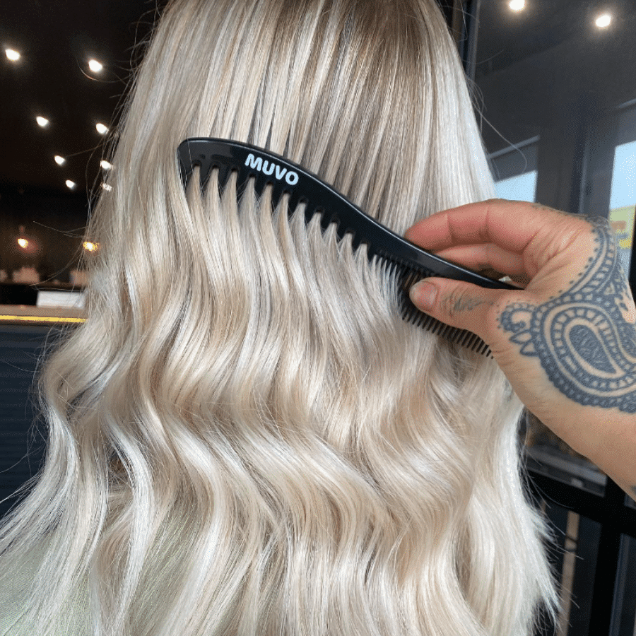 MUVO comb being combed through platinum blonde hair