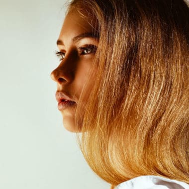 side profile of a lady with very warm blonde hair 