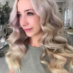 Golvend, bijna krullend blond haar. Lang haar op een meisje in de salon.