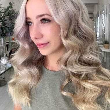 Golvend, bijna krullend blond haar. Lang haar op een meisje in de salon.