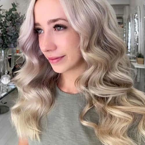 Wavy almost curly blonde hair. Long hair on a girl in salon.
