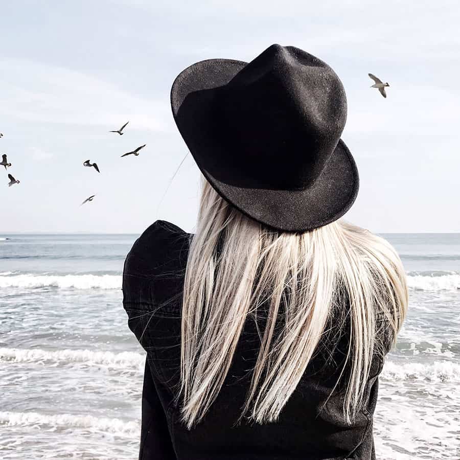 Girl wearing black fedora hat with white blonde hair