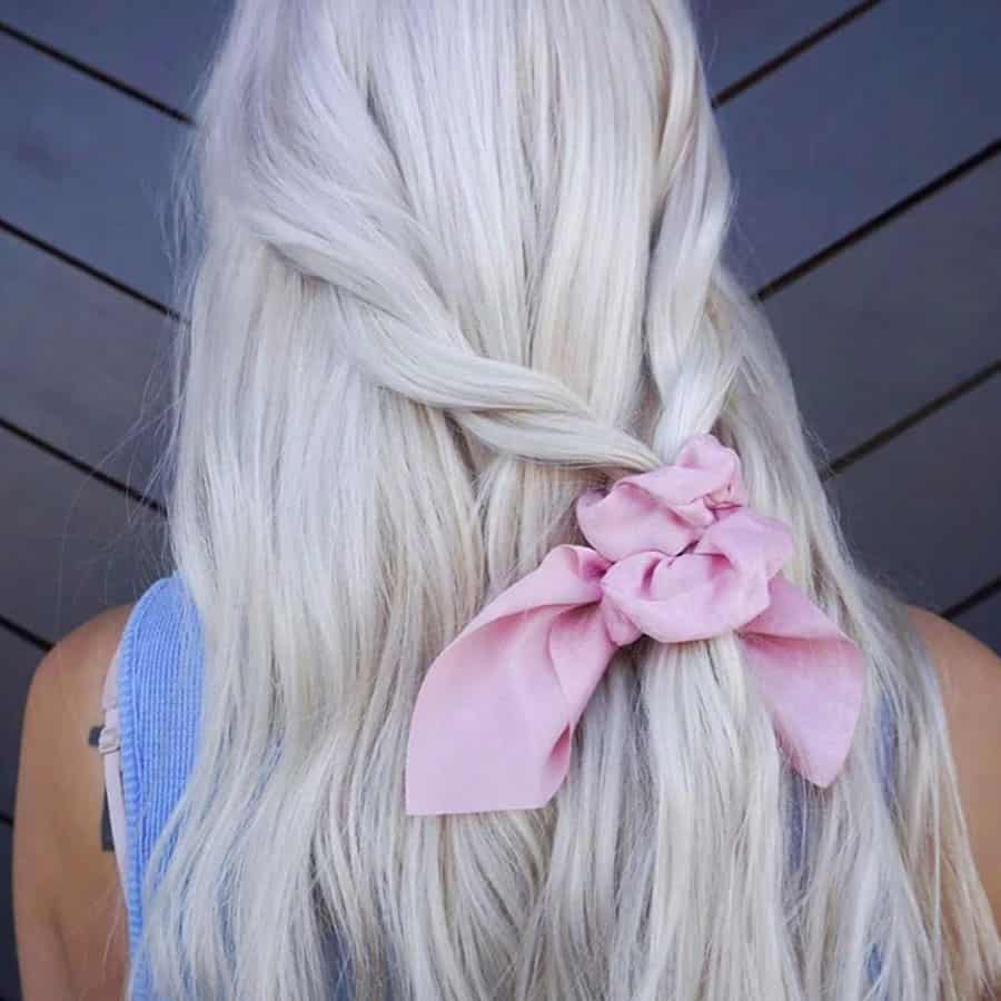 the back of a clean white long blonde hair, lovely plaited and tied loosely with a pale pink ribbon