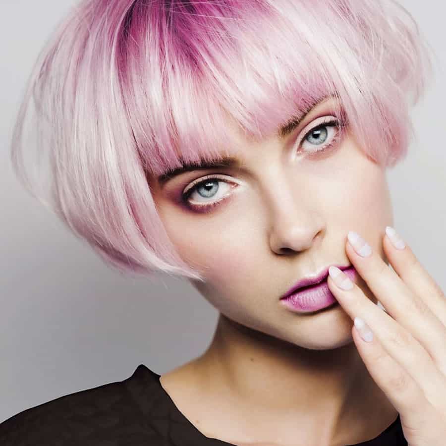 Vibrant pink pixie hair cut and model with pink lipstick and long manicured french nails