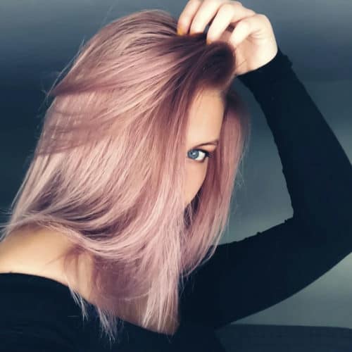 Meisje met roze haar en kan maar één van haar ogen door haar haar zien gluren