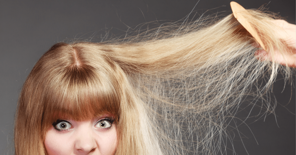 lady with blonde, damaged hair looking scared as her hair is combed