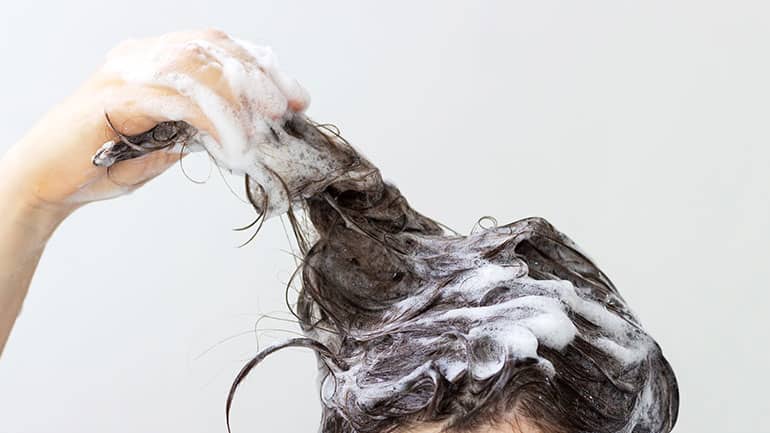 Girl Washing hair with MUVO Deep Cleansing Shampoo