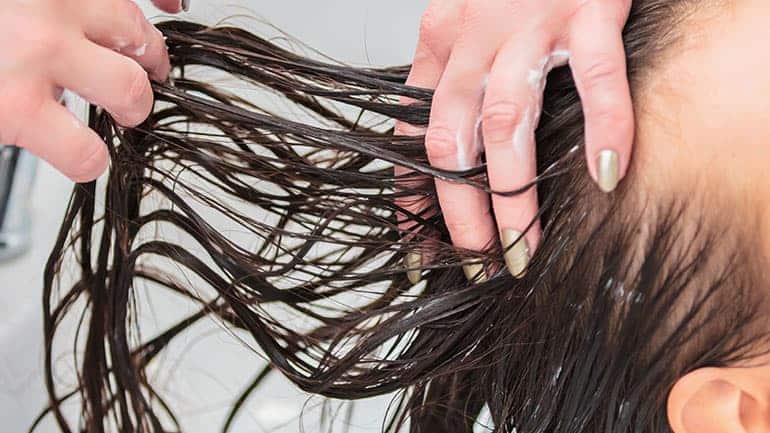 Hairdresser encouraging new hair growth and stimulate the scalp with MUVO Deep Cleansing Shampoo