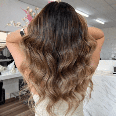 Woman with brunette balayage hair waved