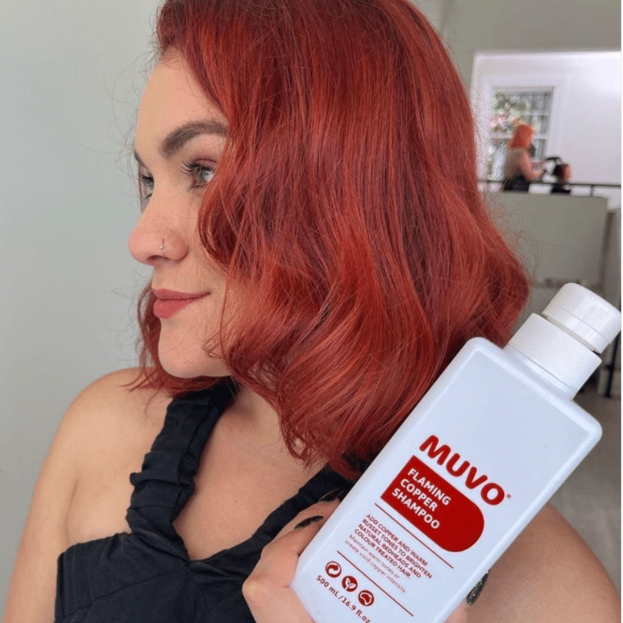 woman with coloured red hair holding a bottle of Flaming Copper Shampoo